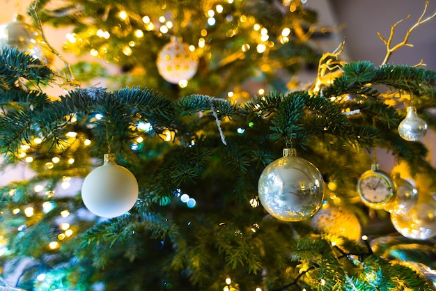 Baubles Adorn a Christmas Tree with Twinkling Lights in the Background