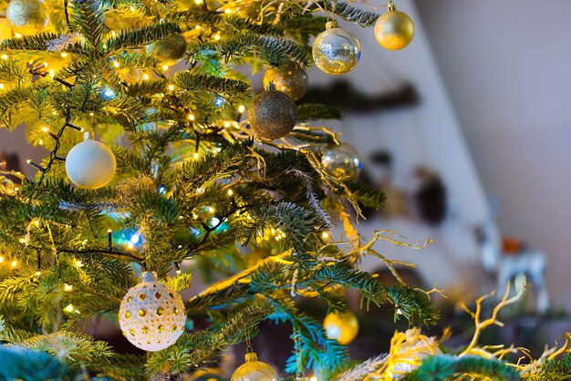 Photo baubles adorn a christmas tree with twinkling lights in the background