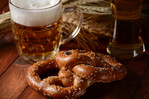 Фото Баварский свежеиспеченный домашний мягкий крендель с пивом октоберфест в деревенском стиле