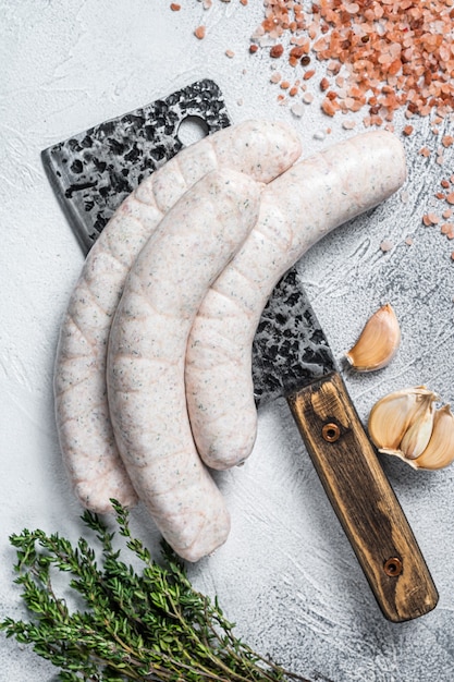 Bavarian traditional white sausages on a meat cleaver. White background. Top view.