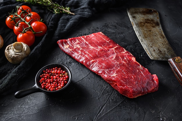 Bavette steak in de buurt van slagersmes met roze peper en rozemarijn