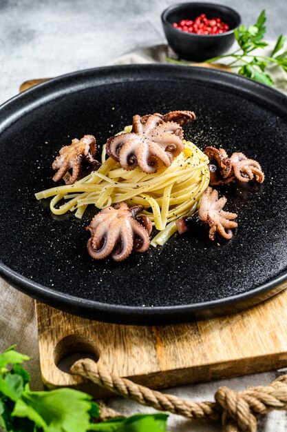 Bavetti pasta met gebakken octopus. Grijze achtergrond. Bovenaanzicht