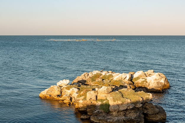 Залив и лазурно-синее Азовское море, вид с травянистого холма. рыболовные сети