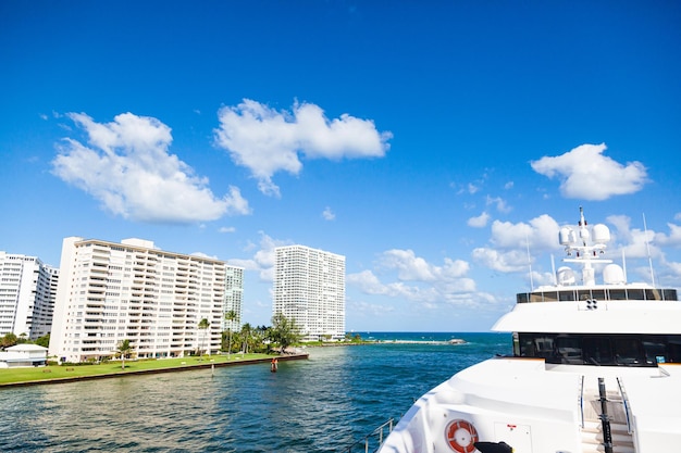 Bay and coastline in clear sunny weather with luxurious houses passing by a luxury yacht