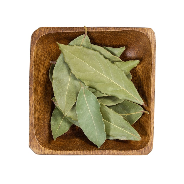 Photo bay leaf in wooden bowl isolated on white background top view