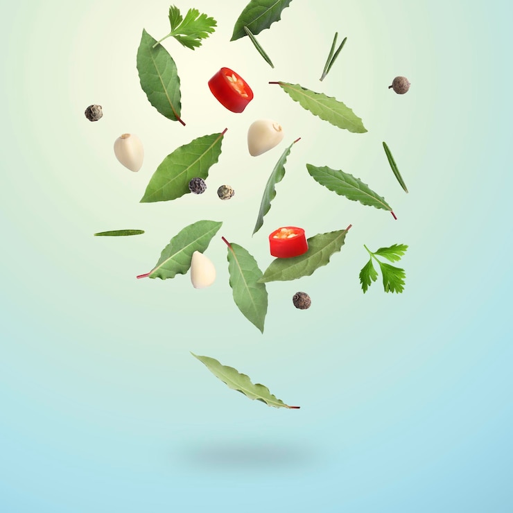Photo bay leaves rosemary parsley garlic cloves black and fresh red hot peppers falling on light blue gradient background