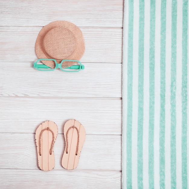Salotto bbeach con scarpe estive, cappello, asciugamano e occhiali da sole