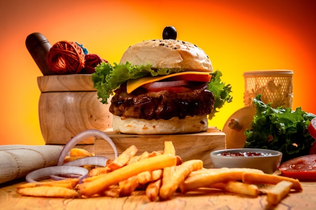 BBQ Beef Cheese burger with french fries potato and tomato slice isolated on wooden board side view on table fast food