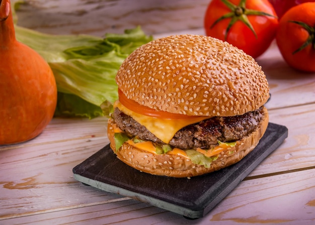 BBQ Cheese Burger isolated on cutting board top view on dark background american fast food