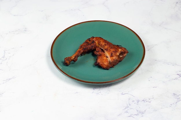 바베큐 치킨 다리 조각은 배경 측면에서 분리된 접시에 제공됩니다.