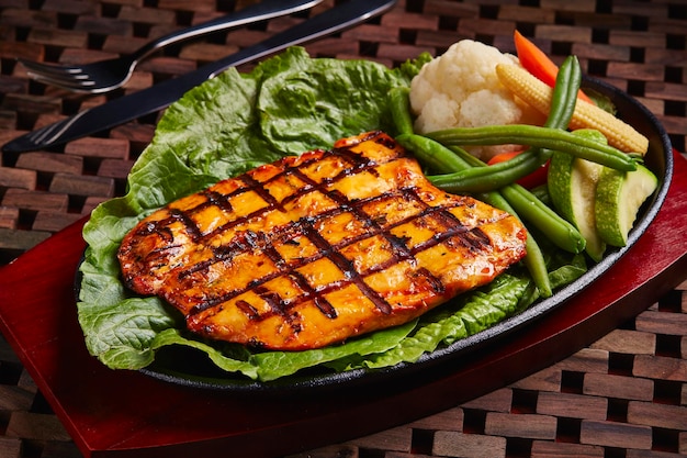 BBQ Chicken steak Fillet Sizzler served in dish isolated on table side view of middle east food