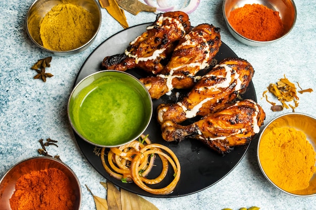 BBq chicken Tangri or tangdi with chili sauce served in a dish isolated on grey background top view of bangladesh food