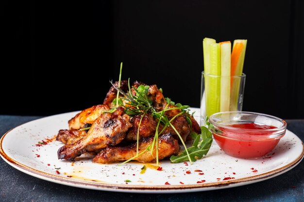 BBQ chicken wings served with ketchup, celery and carrot sticks