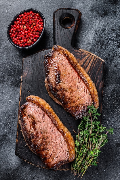 BBQ Gegrilde entrecote of picanha steak op een houten snijplank.