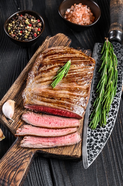 BBQ Grilled flank or flap beef meat steak on a wooden cutting board