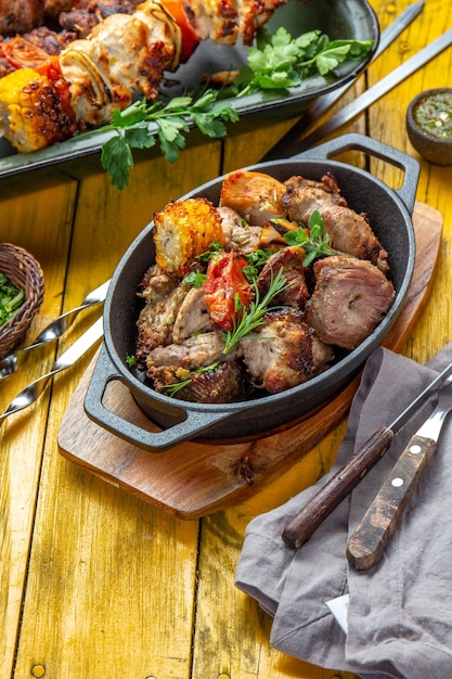 Photo bbq grilled meat pork chicken and vegetable on cast iron pan grilled skewers on yellow wooden