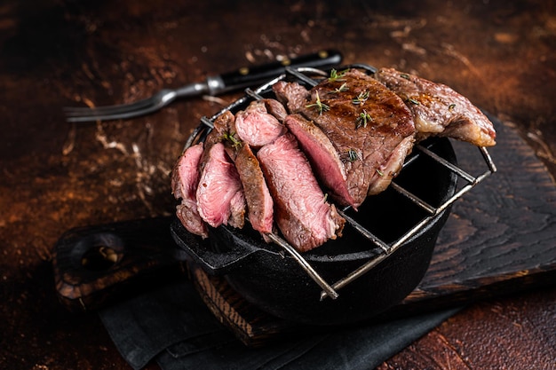 Barbecue alla griglia filetto di montone bistecche tagliate a fette carne di agnello sfondo scuro vista dall'alto