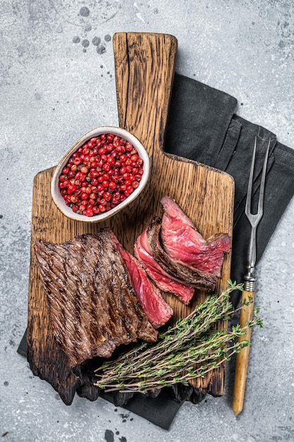 BBQ Grilled Wild Venison steak on wooden board Gray background Top view