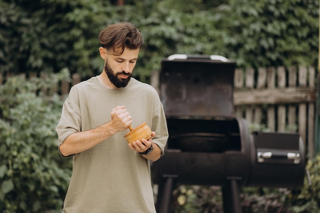 BBQ Guy - グリルの背景にある男料理人でもあり火で料理するファンでもあります