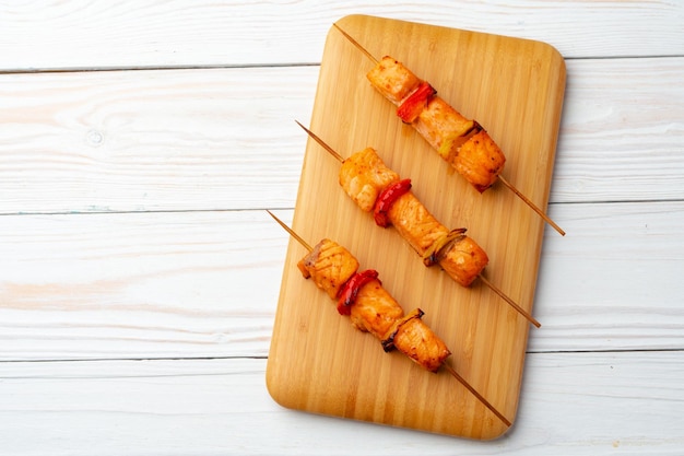 Bbq-kebab op de spiesen geserveerd op houten bord