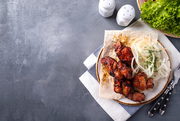 Bbq meat with onion on a plate. Kebabs, Copy space. Top view