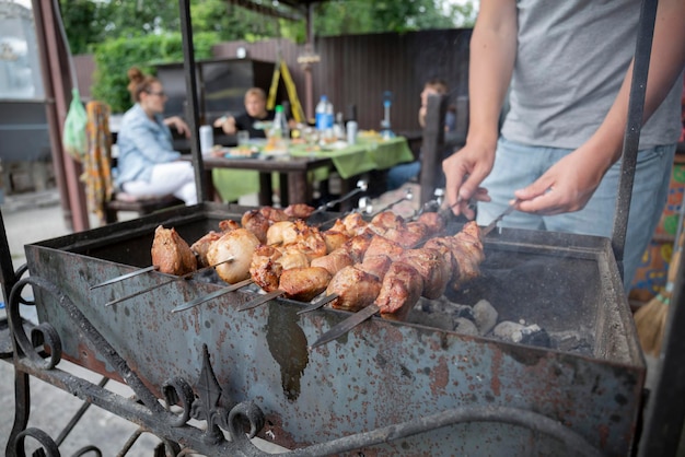 여름날 개인 주택 뒤뜰에서 모닥불에 케밥과 고기를 곁들인 바비큐 피크닉