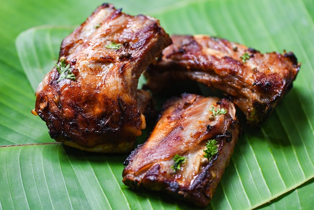 Bbq pork ribs grilled with herbs spices served on banana leaf 