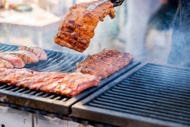 BBQ ribs Hands in gloves overtake fried ribs on the grill