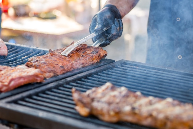 BBQ ribs Hands in gloves overtake fried ribs on the grill