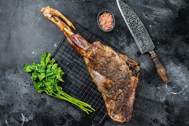 Photo bbq roasted lamb mutton leg with herbs and spices on a grill black background top view