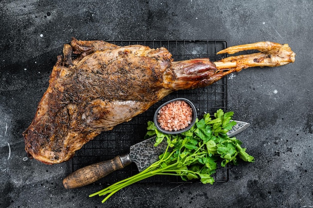 Photo bbq roasted lamb mutton leg with herbs and spices on a grill black background top view