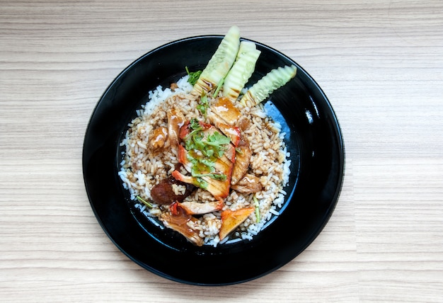 BBQ &amp; roasted pork on stream rice with sweet source in black dish on the wood table