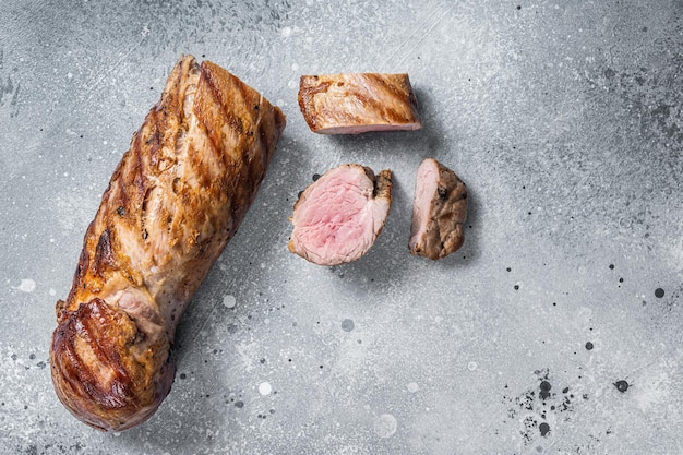 BBQ roasted pork tenderloin fillet meat Gray background Top view Copy space