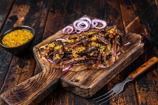 BBQ Sandwich with slow roasted pulled pork meat. Dark wooden background. Top view.