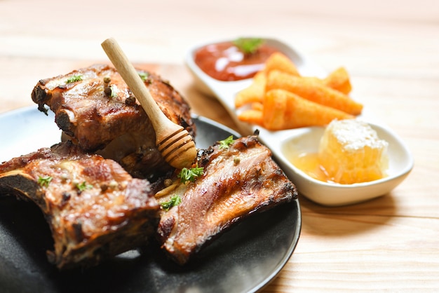 Bbq varkensribbetjes gegrild met honing zoete saus en kruiden specerijen geserveerd op tafel Geroosterde barbecue varkensribbetjes gesneden