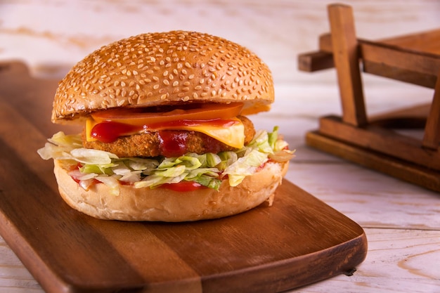 BBQ VEGGIE BURGER изолирован на разделочной доске, вид сверху на темном фоне, американский фаст-фуд