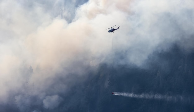 BC Forest Fire and Smoke over the mountain near Hope during a hot sunny summer day British Columbia Canada Wildfire natural disaster