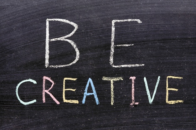 Be creative phrase handwritten on school blackboard