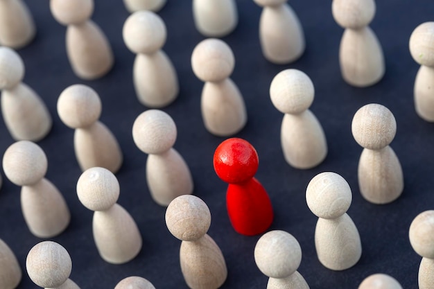 Foto essere diverso, essere un leader, guidare. espressione di icona con figure in legno colorate. concetto di lavoro di squadra, squadra di figure di bastoncini di legno.