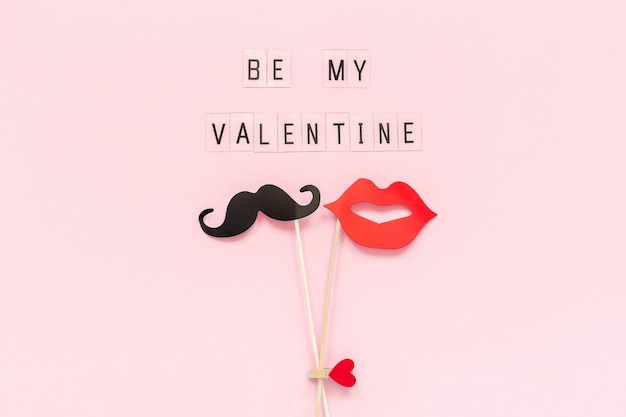  Be my Valentine and couple paper mustache, lips props on pink background.