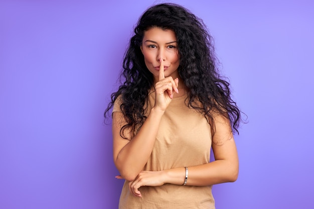 Stai calmo per favore. donna mostra gesto di silenzio, tenendo il dito vicino alla bocca