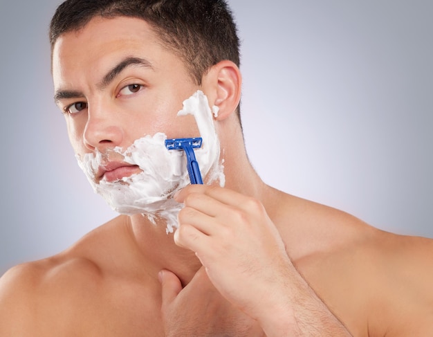 Be serious but not harsh. Shot of a handsome young man shaving his facial hair.