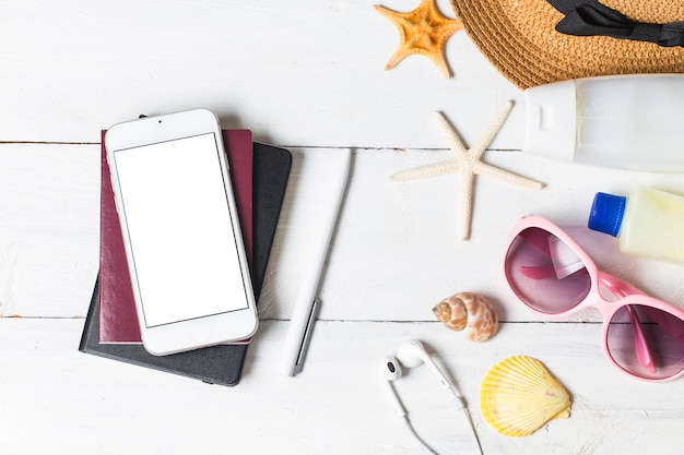 Foto accessori da spiaggia. borsa, asciugamano, occhiali da sole e flip-flop su fondo in legno. vista superiore con spazio di copia