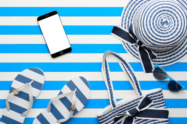 Beach accessories on a blue and white background. Top view, flat lay.