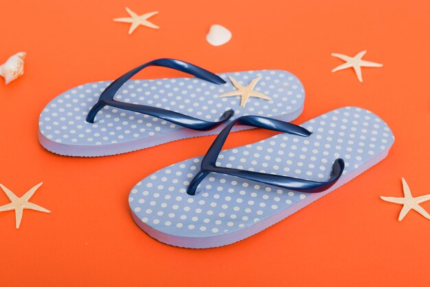 Beach accessories Flip flops and starfish on colored background Top view Mock up with copy space