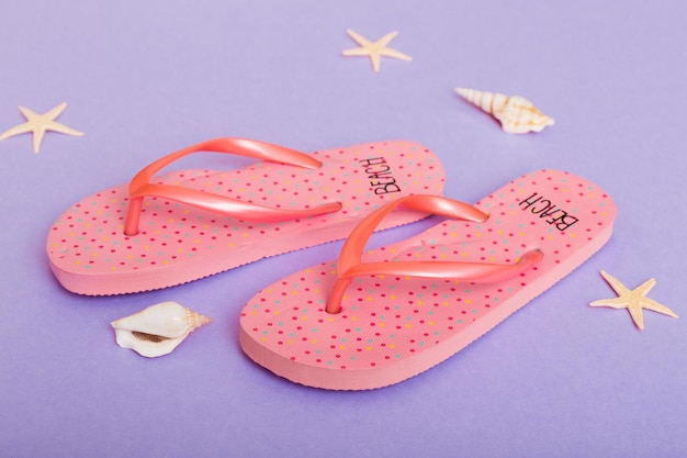 Beach accessories Flip flops and starfish on colored background Top view Mock up with copy space