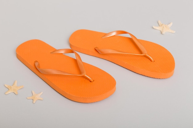 Beach accessories Flip flops and starfish on colored background Top view Mock up with copy space