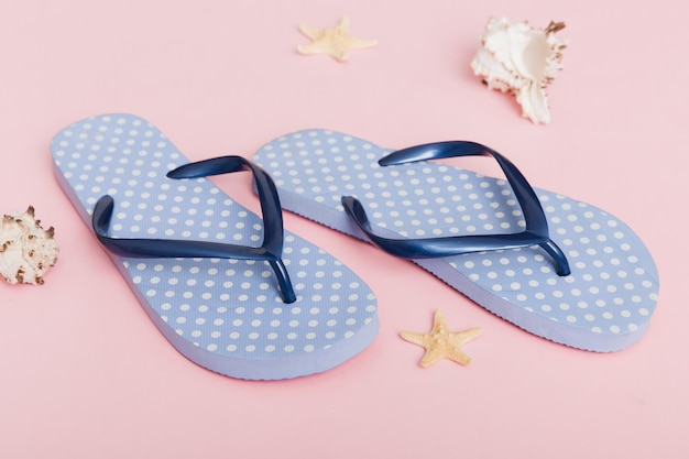 Beach accessories Flip flops and starfish on colored background Top view Mock up with copy space