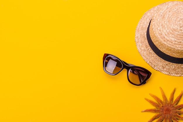 Beach accessories: glasses and hat with shells and sea stars. Summer background