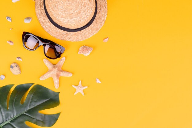 Beach accessories: glasses and hat with shells and sea stars.